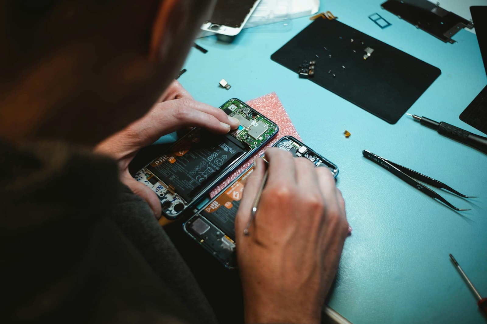 Technician carefully repairing a smartphone at the workbench