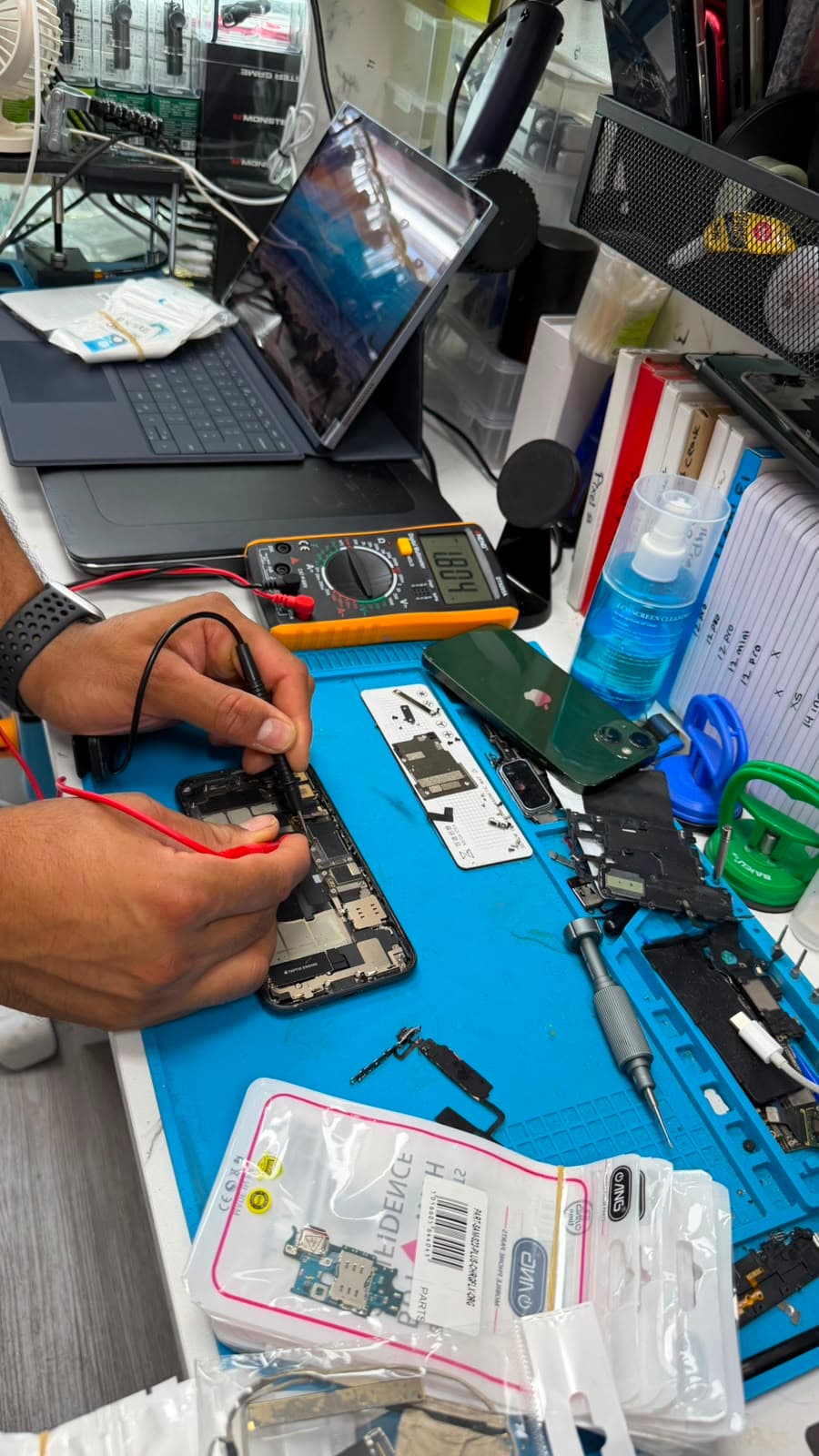 Technician repairing a phone at the Greenwich Gadgets workbench
